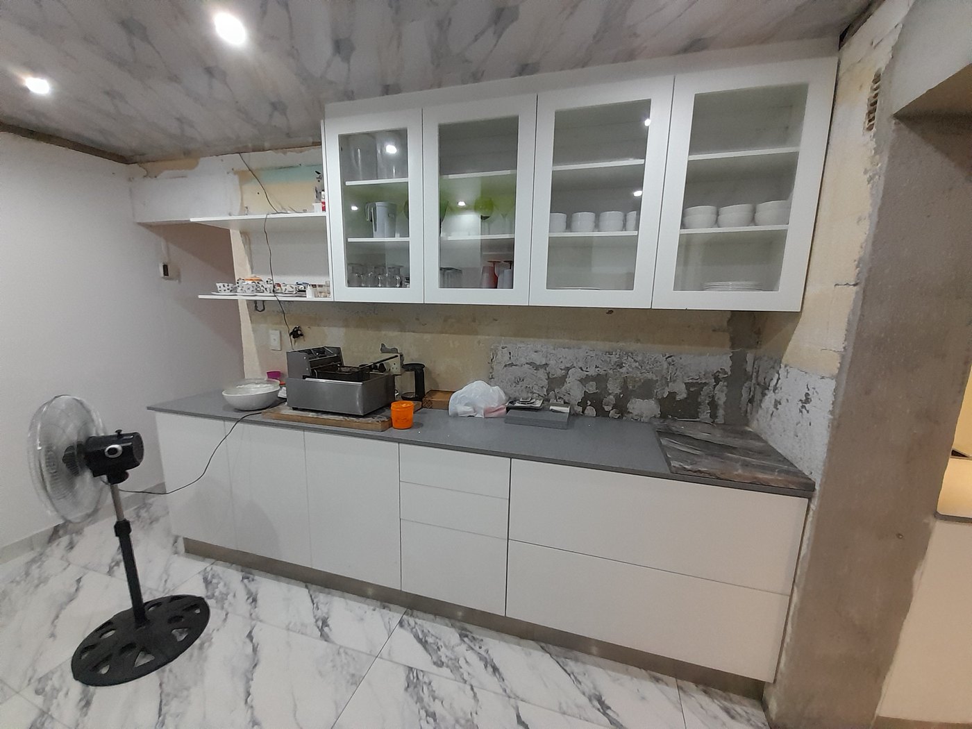 Glass-fronted wall units going in during a kitchen installation