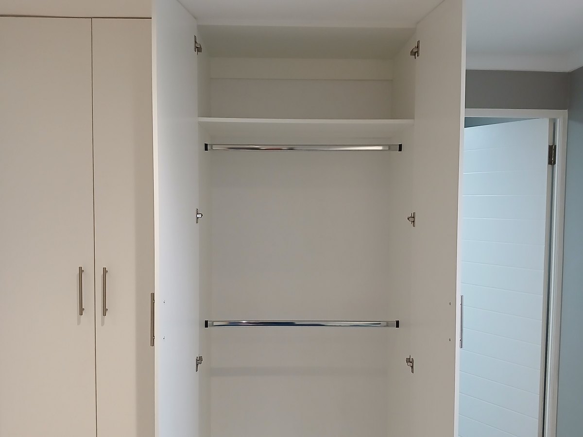 Built-in bedroom unit with drawers and overhead cupboards