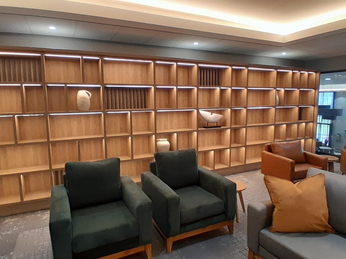 Full-height timber library shelving in a hotel lounge