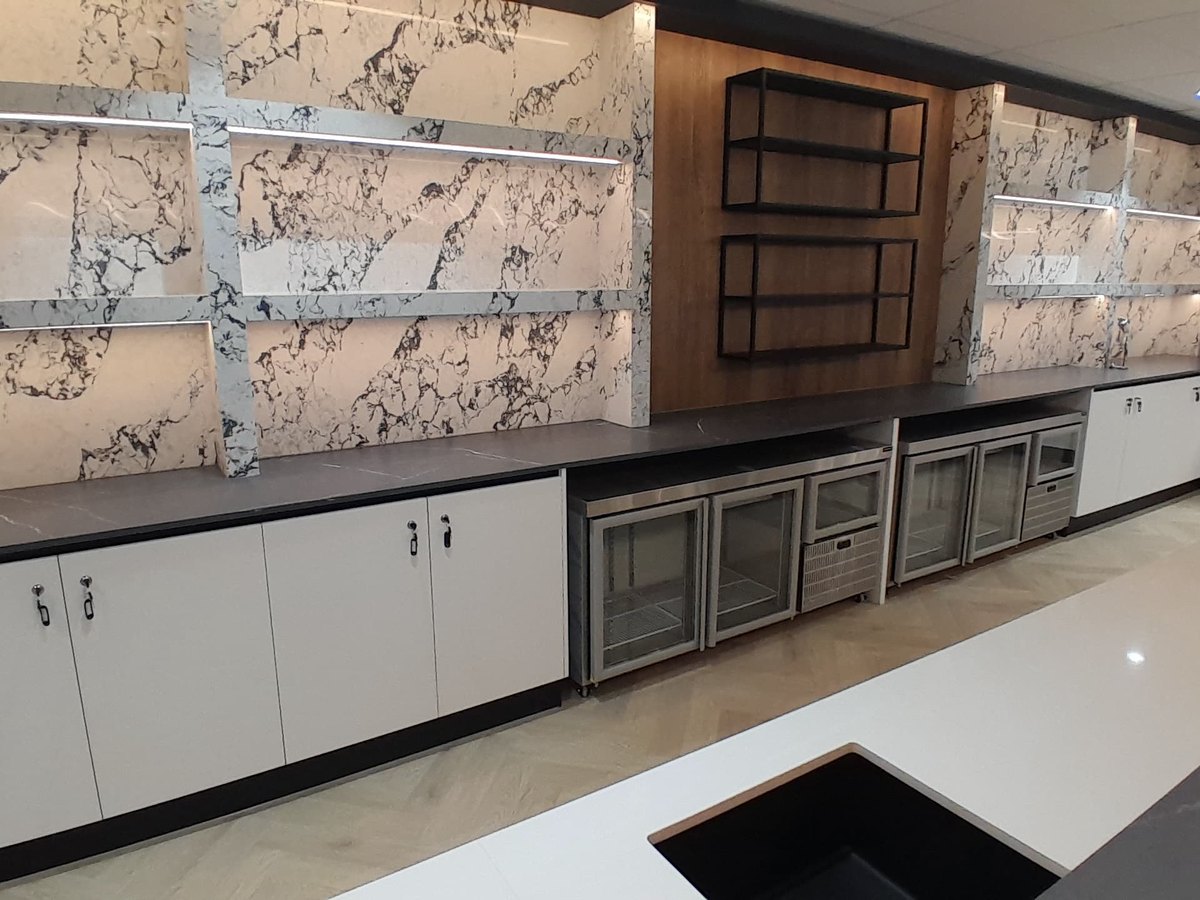Stone-clad servery with fitted cupboards and open shelving