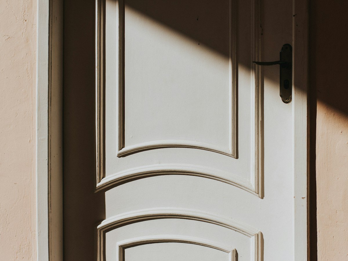 Panelled timber door and handle in afternoon light