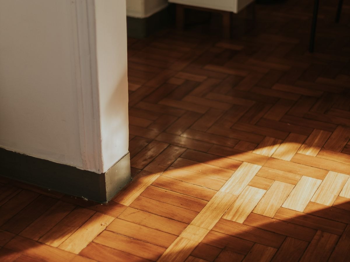 Laminated timber flooring running into a sunlit room