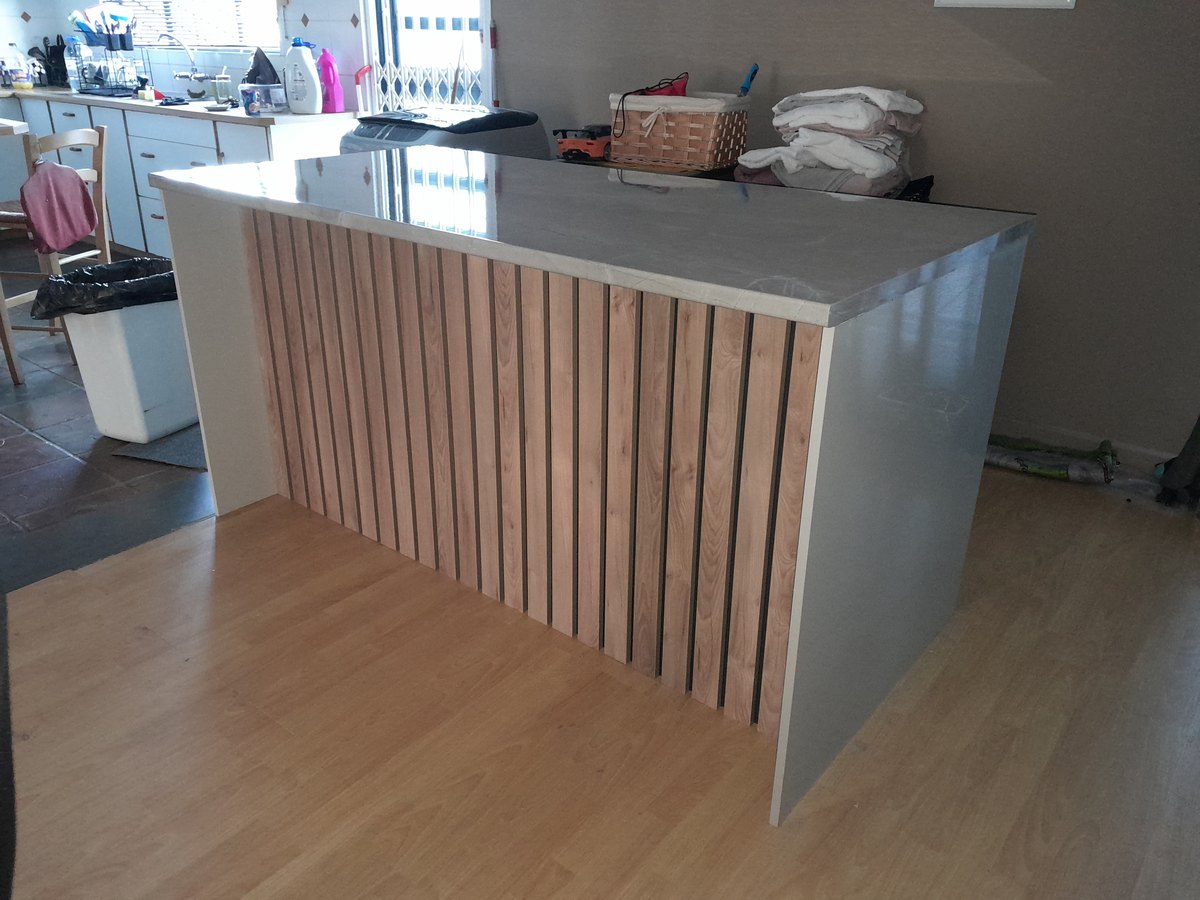 Kitchen island with a slatted timber front